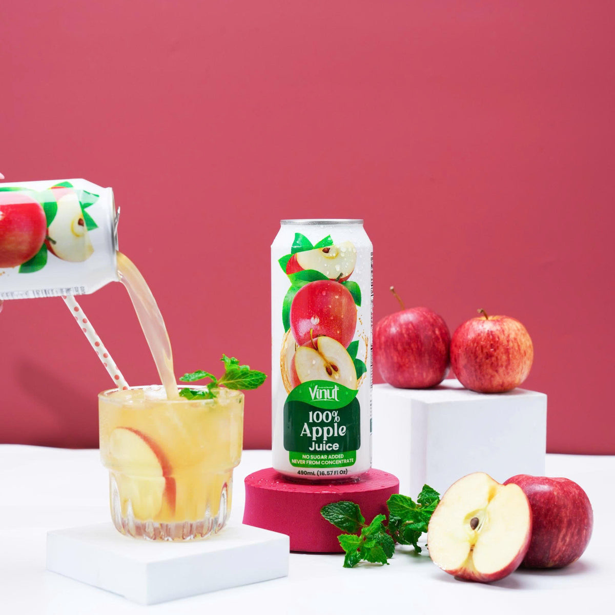 VINUT 100% apple juice can on table poured into glass with fresh tropical fruit