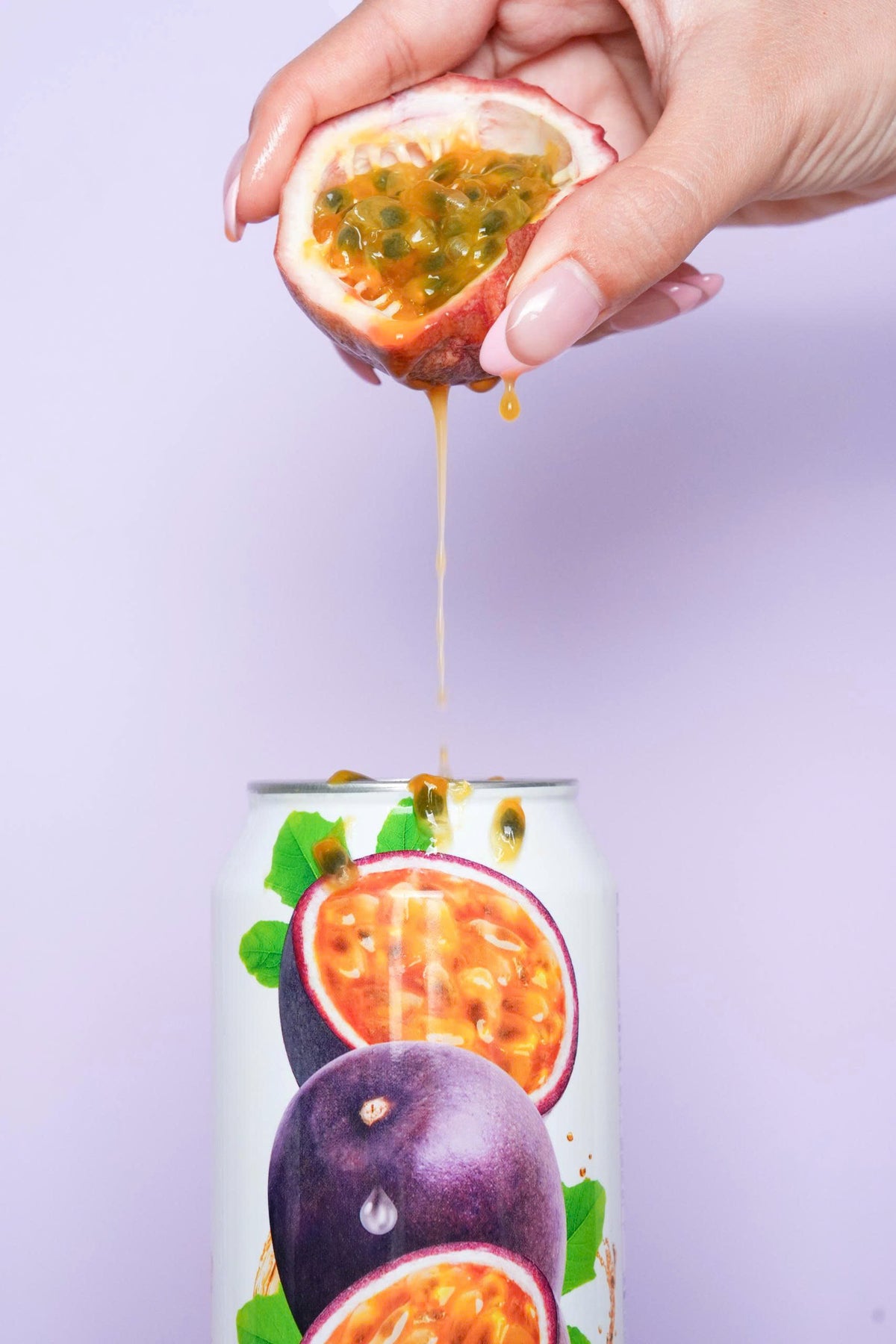 VINUT 100% passion fruit juice can on table with passion fruit squeezed into it