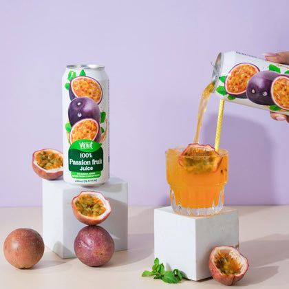 VINUT 100% passion fruit juice can on table poured into glass with fresh tropical fruit