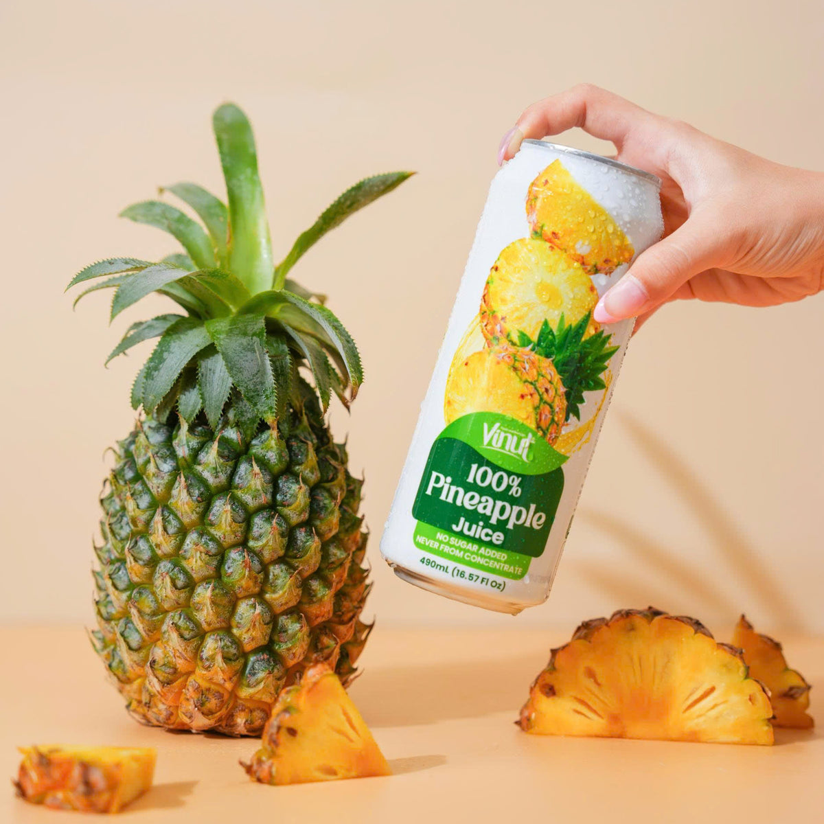 VINUT 100% pineapple juice can on table with fresh tropical fruit